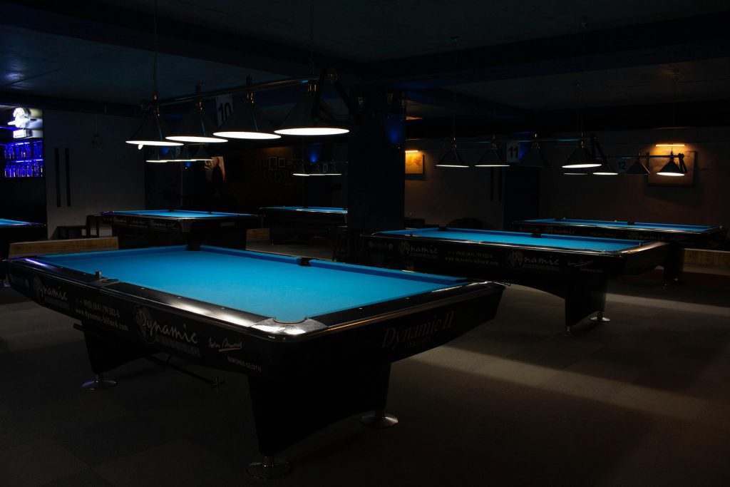 blue-felted pool tables in bar setting